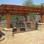 Gazebo ouvert d'été: sur les piliers en pierre se trouvent de puissants supports en bois