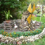 Ceci est une bordure pour un parterre de fleurs pavé. La technique utilisée est différente - un rouleau est formé à partir d'une solution semi-sèche, de petites pierres y sont collées