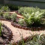Une clôture de parterre de fleurs soigneusement faite de bouteilles en plastique