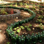 Les bouteilles assorties en taille et en couleur créent une belle enceinte. Des parterres de fleurs à faire soi-même et des parterres de fleurs avec leur aide peuvent être réalisés à la campagne ou à proximité d'une maison privée