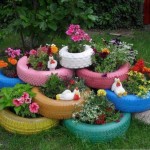 Des pneus de différentes tailles peints de différentes couleurs sont empilés les uns sur les autres. Simplement? Oui! À quoi cela ressemble-t-il? Bien! Option économique d'un parterre de fleurs pour la résidence d'été d'un automobiliste