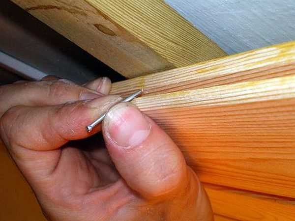 Fixation de la doublure avec un clou (vis autotaraudeuse, agrafe) dans la rainure