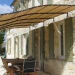 Pergola légère au-dessus de l'entrée - un auvent est tendu sur un cadre métallique