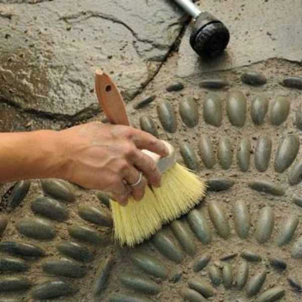 L'excès de coulis de béton est enlevé avec une brosse