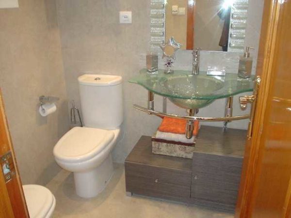 Le lavabo en verre n'encombre pas l'espace. Même une petite salle de bain a l'air spacieuse