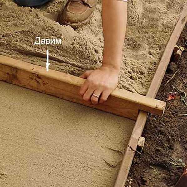 Une façon de niveler le sable sous la passerelle. Mais vous devez d'abord creuser les planches et les mettre de niveau. Ensuite, ils font un tel flan et nivellent le sable en le tirant le long des guides