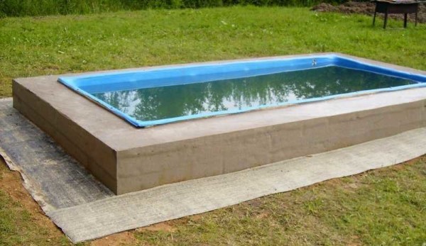 Le matériau de toiture est posé sur le sol nivelé autour de la piscine