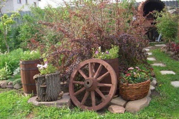 La conception de jardin rustique est facilement reconnaissable à la présence de roues de chariots, de paniers, de plats en céramique, qui sont utilisés de la manière la plus inattendue