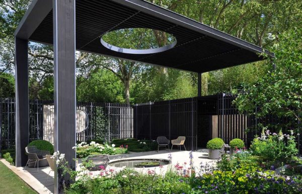 Gazebo insolite: un toit troué illumine un petit étang. Si vous le souhaitez, vous pouvez déplacer les chaises à l'ombre ou au soleil