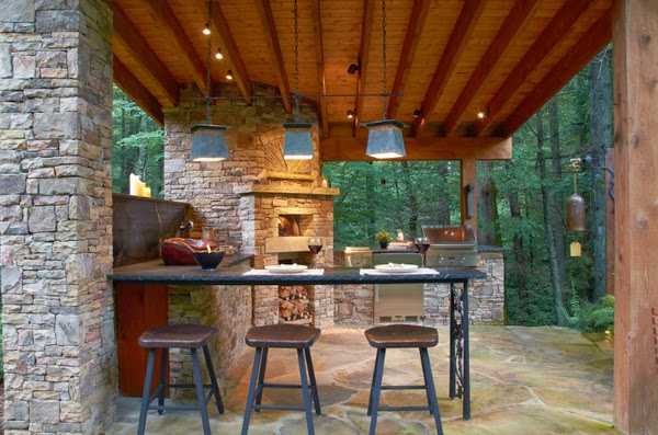 Réalisation sur le côté de la maison - une terrasse ouverte avec four et barbecue