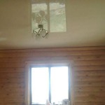 Plafond tendu brillant dans une maison en rondins