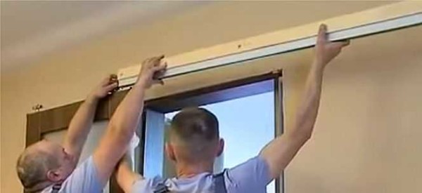 Un guide avec une barre est enroulé sur les rouleaux de la porte