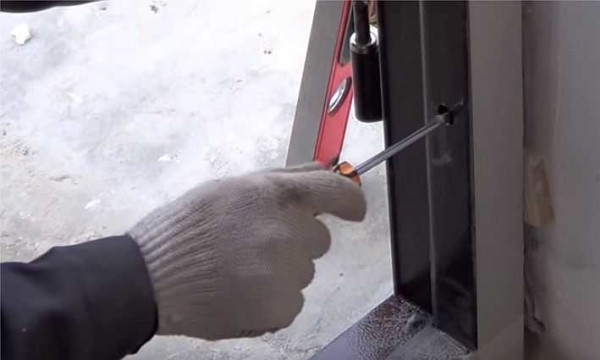 Nous mettons l'ancre dans le cadre de la porte d'entrée par le bas, en vérifiant la verticalité du rack