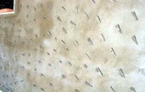 Si la surface du mur est trop lisse, des entailles sont faites dessus.