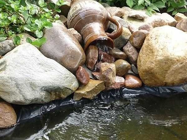 Une erreur courante lors de la décoration d'une cascade - les côtés du bol ne sont pas tapissés de pierre et le film gâche une bonne idée