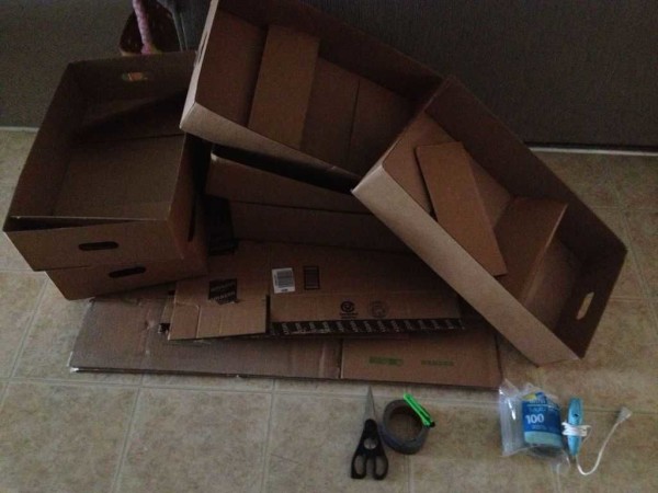 Carton d'emballage, colle chaude, pistolet, ruban à mesurer, ciseaux, couteau à papier peint tranchant - tous les outils nécessaires à la construction