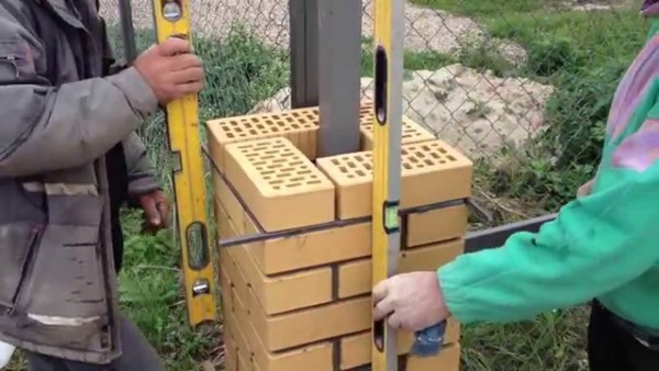Les poteaux de clôture sont posés autour d'un tuyau de renfort métallique