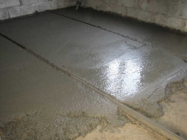 Alors ils coulent le sol en béton dans le garage le long des phares