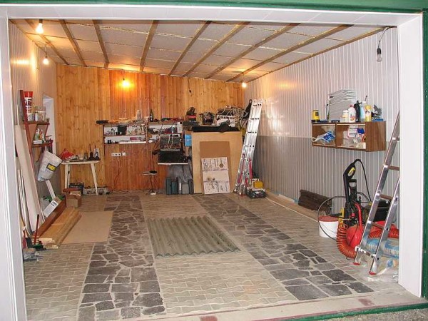 Le sol du garage est fait de dalles de pavage, des dalles de granit naturel sont posées sous les roues
