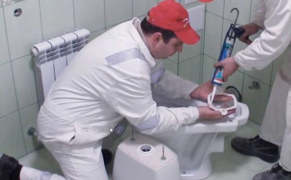 Nous enduisons le joint de silicone, le mettons sur les toilettes