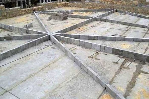 Une autre façon de former une pente est de fixer les guides avant de couler la chape et de niveler le béton le long d'eux.