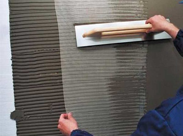 Le treillis est déroulé sur la couche de colle posée, pressé dedans avec une spatule