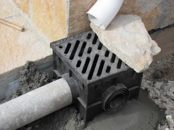 Installation d'une entrée d'eau pluviale - versez du béton et chargez avec quelque chose de lourd pour ne pas faire sortir