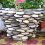 Décorer un pot de fleurs en béton avec des galets