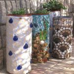 Finition d'un pot de fleurs en béton avec des morceaux de carreaux