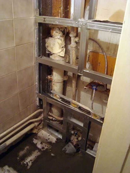 Si les tuyaux sont sur le mur du fond et que les toilettes sont étroites et longues, il est logique de coudre complètement le mur du fond.