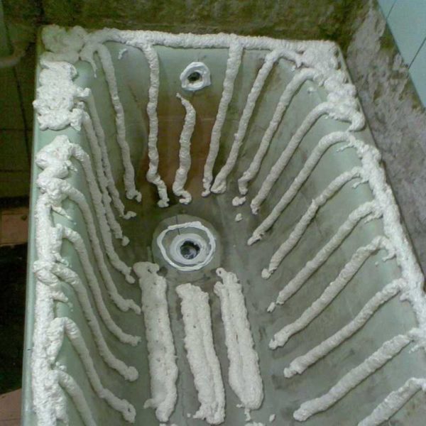 Un exemple d'application de mousse sous un insert de bain acrylique