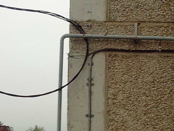 Pose du câble dans le tuyau.Ils fixent le tuyau et le câble ne le sort que vers le mur