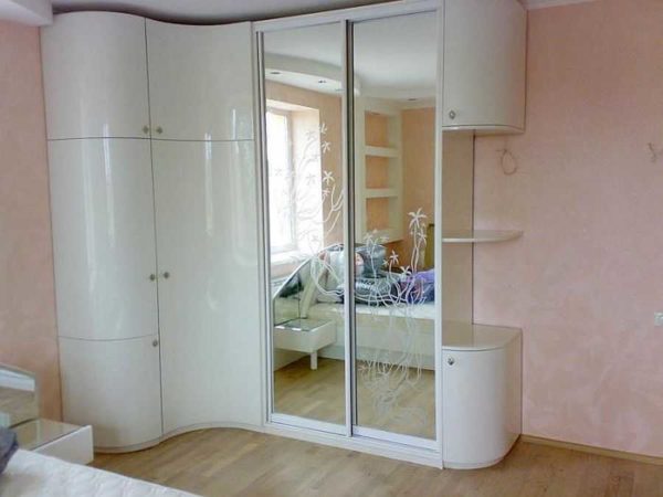 Brillant blanc et miroir. Cette armoire de taille solide n'a pas du tout l'air encombrante
