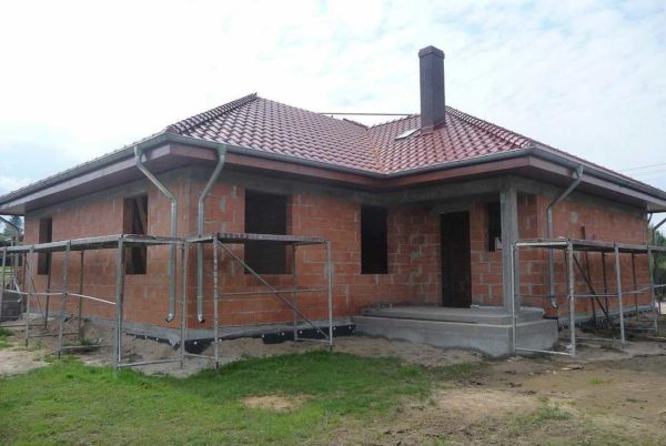 Une telle maison avec une disposition en forme de L coûte plus cher qu'une maison rectangulaire ou carrée