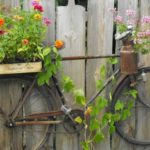 Décorez la clôture en y épinglant un vieux vélo ... et plantez des fleurs sur le vélo
