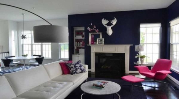Le bleu cobalt intense, presque noir, est la toile de fond parfaite pour un fauteuil fuchsia