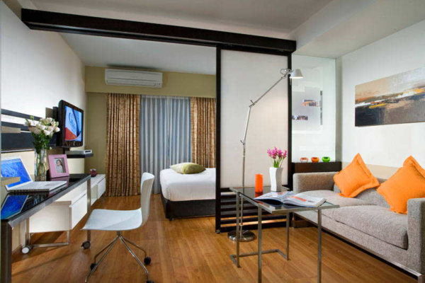 Un lit dans un salon avec une chambre dédiée est généralement placé loin de l'entrée.