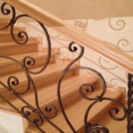 Rampe d'escalier forgée avec fixation latérale. Les attaches sont immédiatement intégrées à la balustrade