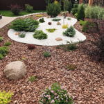 Les copeaux comme paillis et pierre concassée décorative économiseront pendant que les plantes sont petites