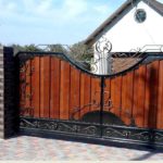 Représentant du deuxième type - portes forgées et une clôture recouverte de planches