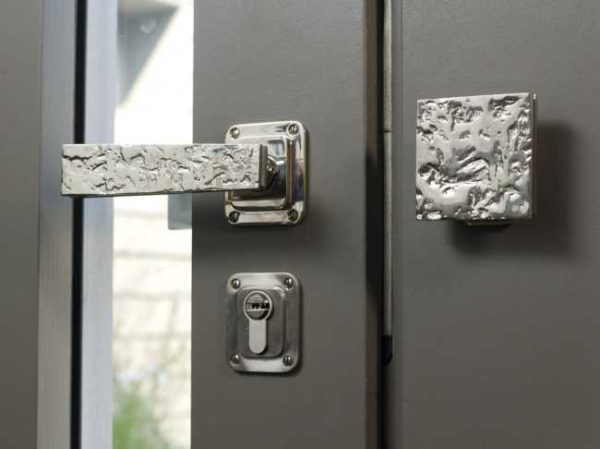 Sur les portes doubles, il y a un ensemble - une poignée avec un loquet et un fixe